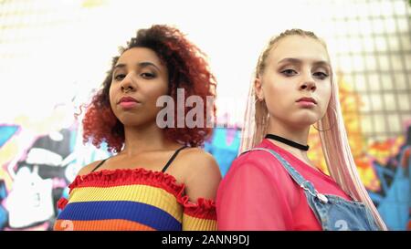 Urban female friends looking camera, puberty self-expression, street style Stock Photo