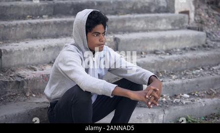 Pensive american millennial sitting alone thinking of problem, disappointment Stock Photo