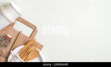 Zero waste picnic travel set with reusable wooden cutlery, glass bottle, paper cups and plate, biodegradable utensils. Top view with copy space. Eco s Stock Photo