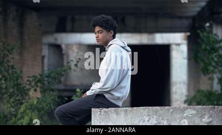 Depressed lonely black male sitting abandoned building thinking of problem Stock Photo