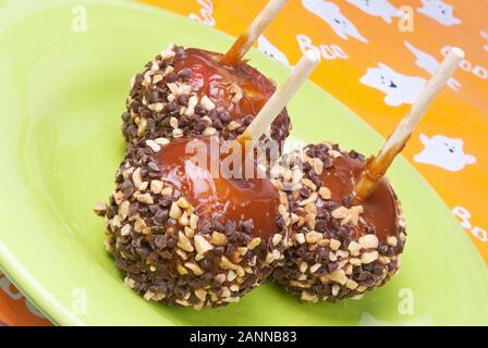Tilt perspective shot of toffee candy apples with a caramel glaze and dipped in chocolate chips and crushed peanuts. Stock Photo