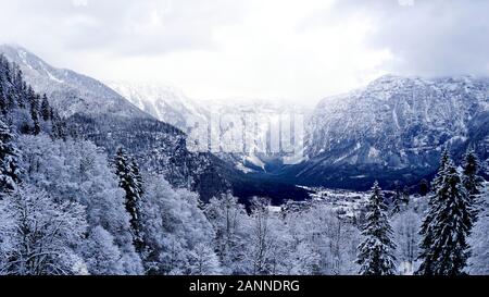 Scenery dreamscape of Hallstatt Winter snow mountain landscape valley and lake through the forest in upland valley leads to the old salt mine of Halls Stock Photo