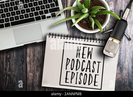 top view of podcast recording equipment on rustic wooden table with words new podcast episode written on spiral notepad Stock Photo
