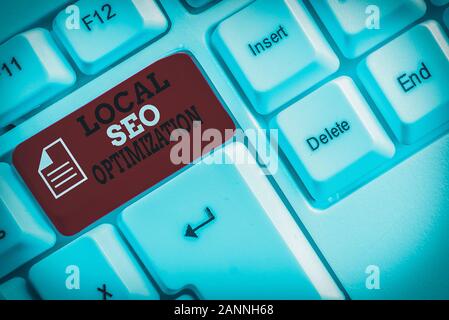 Word writing text Local Seo Optimization. Business photo showcasing increase Search Visibility to Rank on Top list White pc keyboard with empty note p Stock Photo
