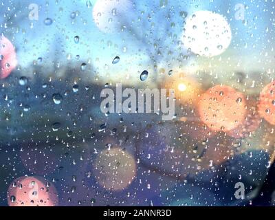 Car window with raindrops on wet winter day at sunset. Stock Photo