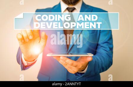 Handwriting text Coding And Development. Conceptual photo Programming Building simple assembly Programs Businessman with pointing finger in front of h Stock Photo