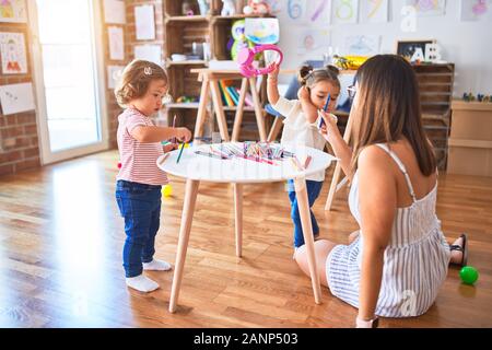 Young beautiful teacher and toddlers playing at kindergarten Stock Photo