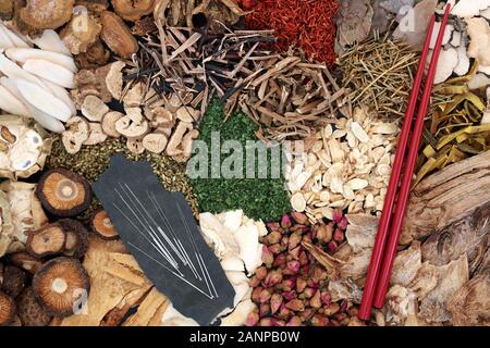 Chinese herbs and acupuncture needles used in traditional herbal medicine with chopsticks forming an abstract background. Flat lay. Stock Photo