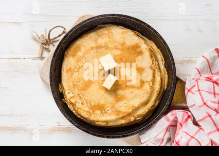 Crepes in the frying pan on white table. Stock Photo