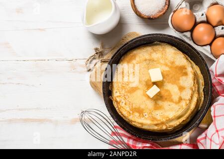 Crepes or thin pancakes in the frying pan with ingredients for cooking. Stock Photo