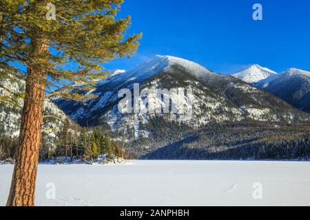 frozen holland lake below carmine peak in the swan range near condon, montana Stock Photo