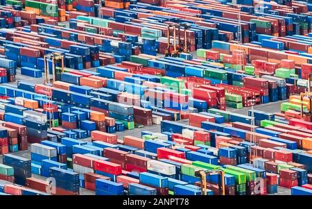 Texture made with an aerial view over shipping cargo containers stacked on a commercial port. Suitable to be used as background