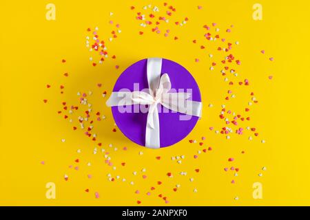 a violet gift box on yellow background. Stock Photo