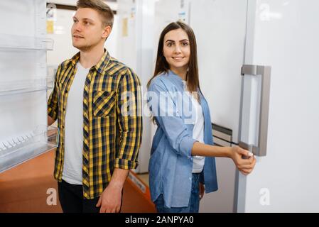 Young couple choosing refrigerator in store Stock Photo