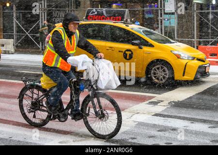 New York, USA,  18 January 2020. A delivery man from a Chinese restaurant works on his bycicle in New York City's Upper East Side during a snowstorm.   Credit: Enrique Shore/Alamy Live News Stock Photo