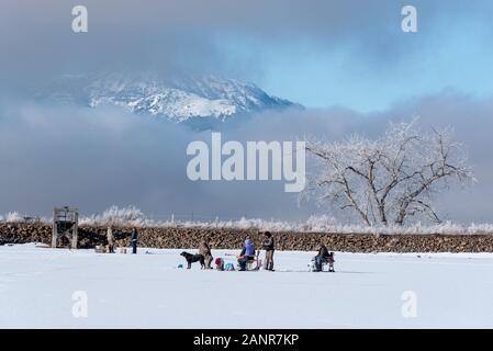 Ice fishing on Kinney Lake, below the Wallowa Mountains, Oregon. Stock Photo