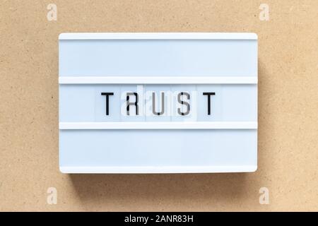 White lightbox with word trust on wood background Stock Photo