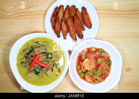 Thai Local food of Green Curry with Beef, Stir Fried Parkia Nuts with Shrimps and Deep Fried Spicy Chicken Wings Stock Photo