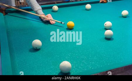 Green billiard table with white balls. Young man playing billiards Stock Photo