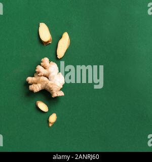Fresh Ginger on green background, creative flat lay, copy space. Healthy asian food concept, ginger root. Stock Photo