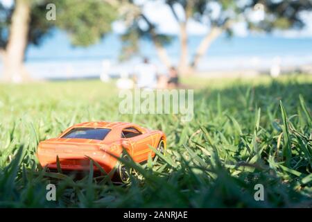 A toy car and family picnic at the beach - forced miniature perspective image