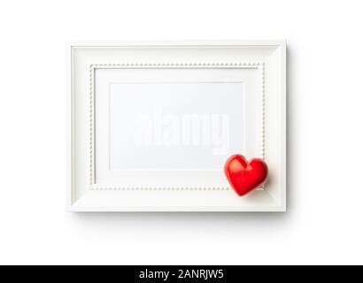 Love Valentine's Day concept. Blank picture frame and red heart isolated on white background. Stock Photo