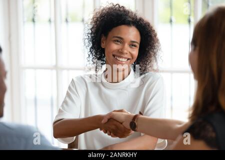 Smiling African American businesswoman shaking hand of client at meeting Stock Photo