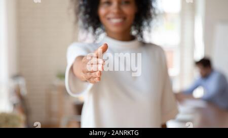 Happy African American businesswoman extending hand at camera, offering handshake Stock Photo