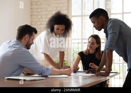Serious focused diverse employees team working with documents together Stock Photo
