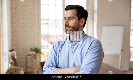 Thoughtful confident businessman looking in distance, pondering strategy Stock Photo