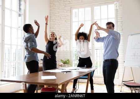 Happy business people celebrating success, dancing at meeting in boardroom Stock Photo