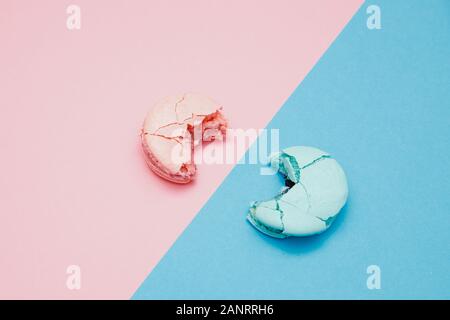 Minimalism, bitten macaroons on pink background, top view. Concept reducing interest rates on loans in banks, taxes Stock Photo