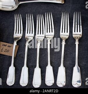 Set of silver forks for sale at a flea market on black velvet. Stock Photo