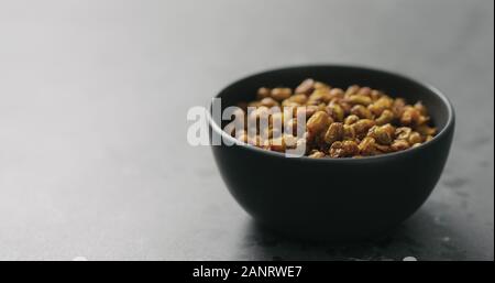 dried seaberry in black bowl on terrazzo countertop, wide photo Stock Photo