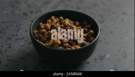 dried seaberry in black bowl on terrazzo countertop, wide photo Stock Photo