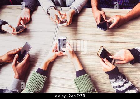 Group of friends having fun together with smart phones - Hands social networking with mobile device - Technology and phone addiction concept - Main fo Stock Photo