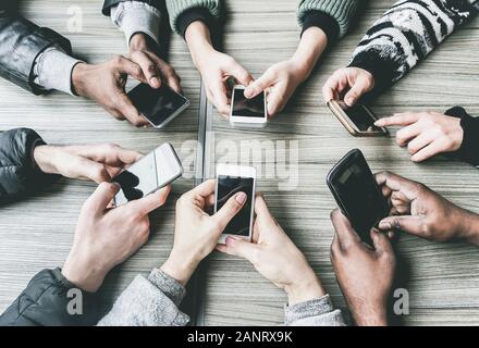 Group of friends having fun together with smartphones - Closeup of hands social networking with mobile phones - Technology and phone addiction concept Stock Photo