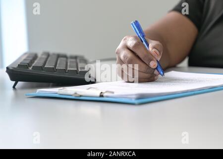 Woman's hand writing on paper with pen. Office table, copy space. Stock Photo
