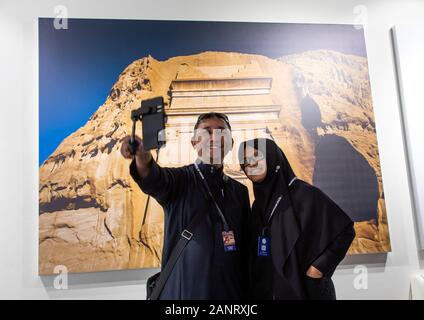 Indonesian tourists taking a selfie in front of a picture of Madain Saleh, Al Madinah Province, Alula, Saudi Arabia Stock Photo