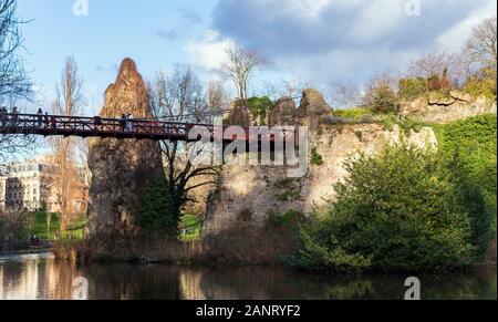 The Parc des Buttes-Chaumont, the red bridge and the lake in winter 2020, fifth-largest public park in Paris, FRANCE. Stock Photo