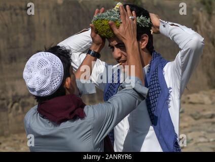 Portrait of a flower man adjusting a floral crown on the head, Jizan province, Addayer, Saudi Arabia Stock Photo