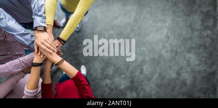 Close up top view of young business people putting their hands together. Stack of hands. Unity and teamwork concept. Stock Photo