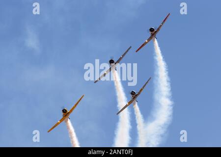Four North American AT-6 Harvard single engine military training aircraft from World War II flying in formation. Stock Photo
