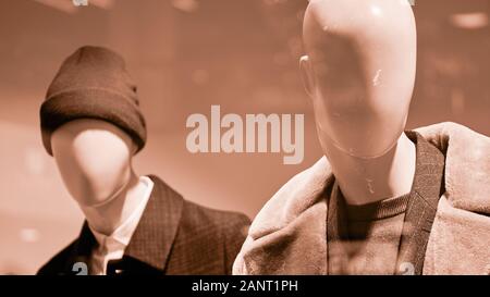 Two mannequins dressed in warm clothes in sepia colors. Close up. Stock Photo