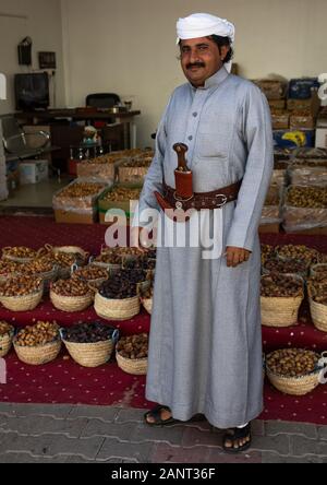 Saudi man in traditional clothing selling sweet dates, Najran Province, Najran, Saudi Arabia Stock Photo