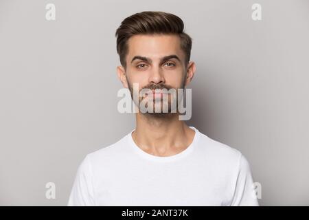 Millennial confident concentrated guy looking at camera portrait. Stock Photo
