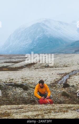 Man hiking in mountains traveling alone vacations outdoor adventure expedition trekking active healthy lifestyle Rondane park landscape in Norway moss Stock Photo