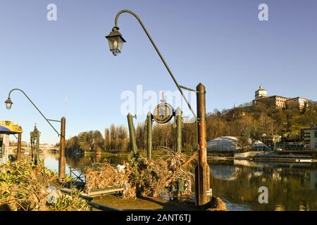 Pier of the Murazzi river bank invaded by rubble of the flood of Po river, with the Monte dei Cappuccini in the background, Turin, Piedmont, Italy Stock Photo