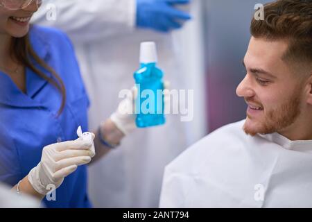 Dentist introducing breath refresher to her patient after teeth exam Stock Photo