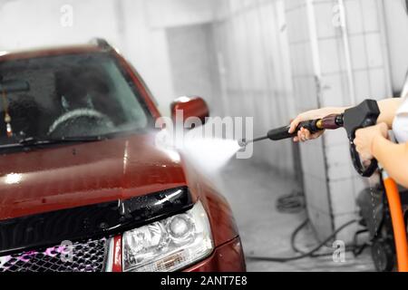 Worker washing car detailing using high pressure water Stock Photo